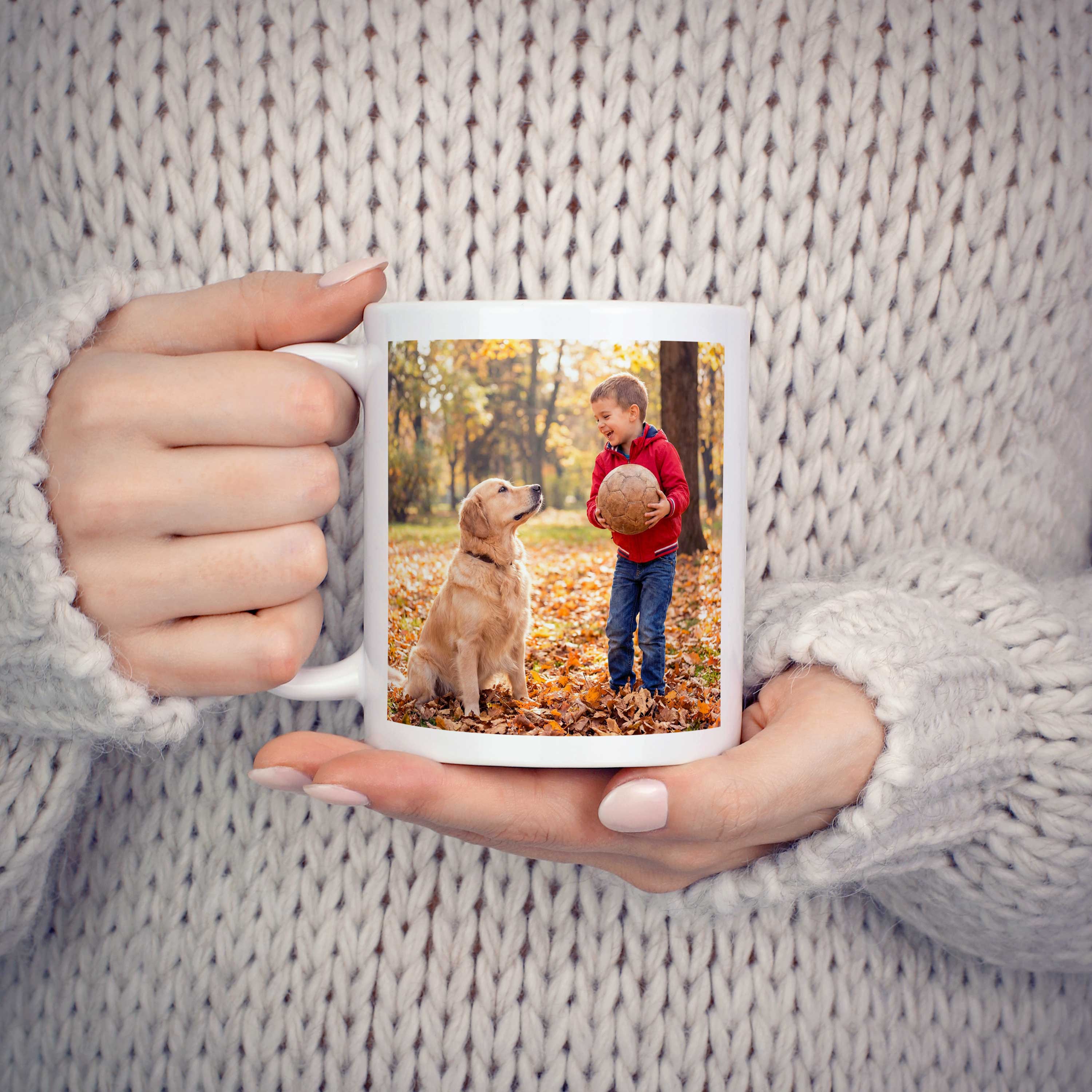 Junge Frau hält eine Pictacor Fototasse in den Händen mit dem Foto ihres Kindes mit dem Hund.