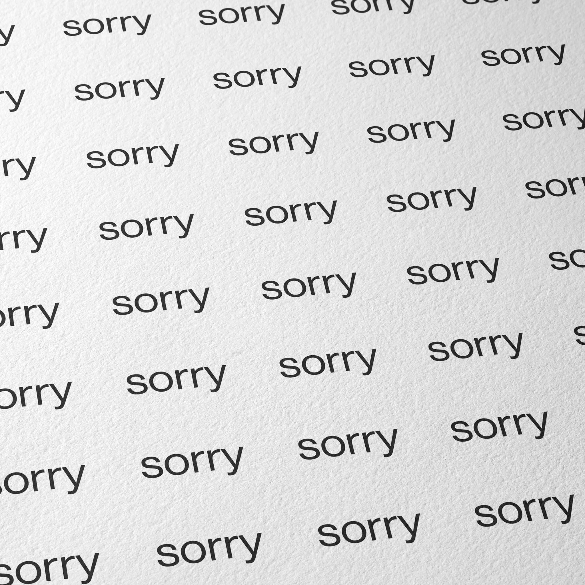 Weißes Fine‑Art‑Papier auf Hahnemühle Photo Rag 308 mit einem gleichmäßigen Raster aus dem Wort „sorry“ in schwarzer Schrift über die gesamte Fläche.